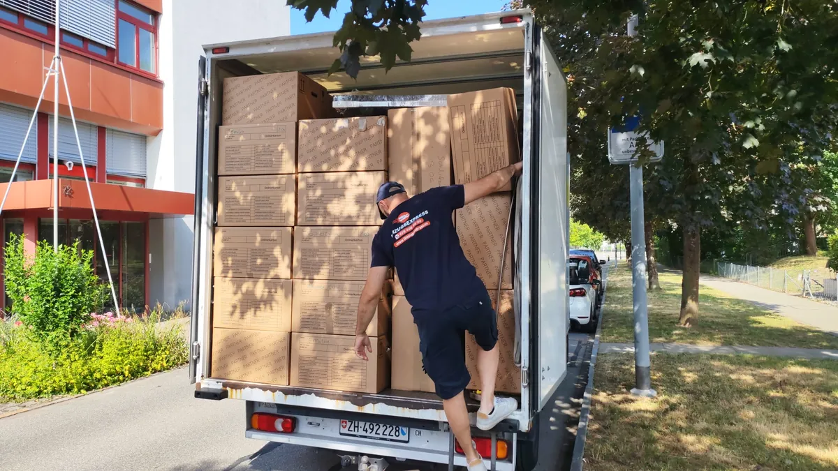 Lastwagen bis unters Dach mit Umzugskartons beladen