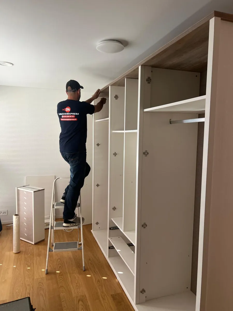 Einsatz von Umzugsexpress: Mitarbeiter montiert einen grossen Kleiderschrank in der neuen Wohnung