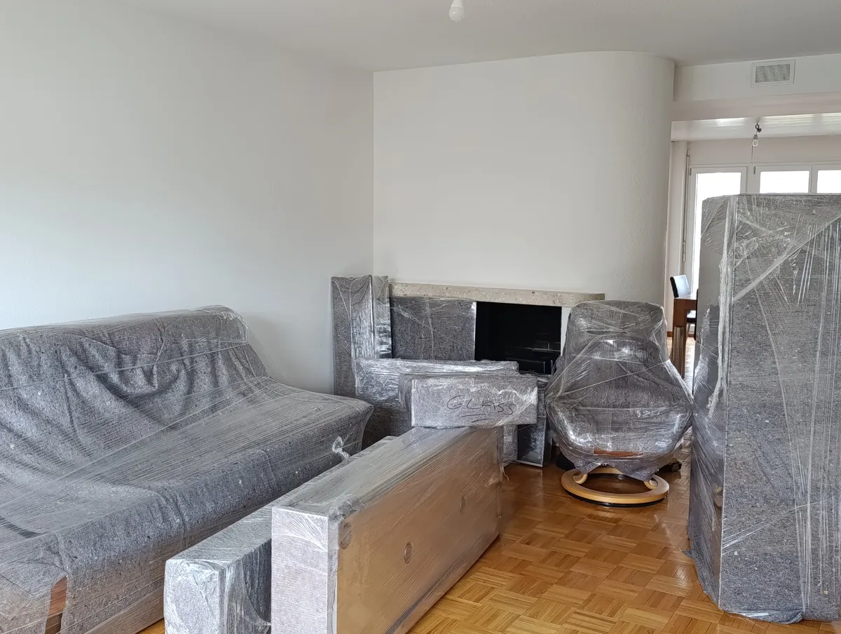 Umzugsexpress job: Move in Dietikon: sofa, armchair and wardrobe wrapped in blankets and film in the living room