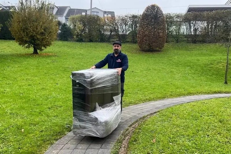 Mitarbeiter transportiert ein verpacktes Möbelstück